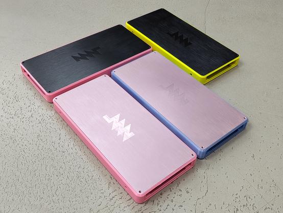 4 potential base/lid color combos: yellow/black, pink/black, pink/pastel purple, translucent blue/pastel purple. the lids are brushed aluminum and have a cnc engraved mnt logo
