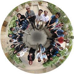 the potential of group process: a circular photograph taken from above of a circle of people looking up toward the camera