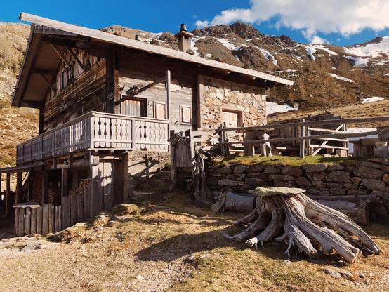 A mountain hut with mountain peaks in the distance