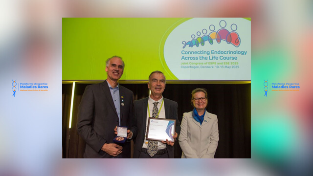 Trois personnes posent sur scène, souriantes. Le Professeur Thierry Brue, au centre, tient une plaque encadrée, accompagné de deux collègues. À l’arrière-plan, l’écran affiche le titre du congrès de Copenhague 2025 : « Connecting Endocrinology Across the Life Course – Joint Congress of ESPE and ESE ». Le visuel est marqué du logo de la Plateforme d’Expertise Maladies Rares – Hôpitaux Universitaires de Marseille.