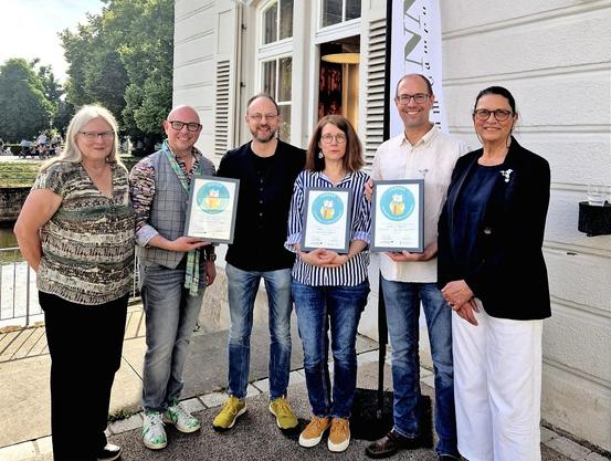 Gruppenbild sechs Erwachsene wovon drei je eine Urkunde zur LeseEule in der Hand halten.