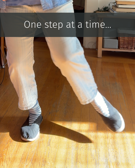 A person mid-step in soft tai chi shoes and striped socks, moving across a sunlit hardwood floor. Text reads, “One step at a time…”