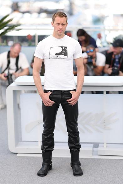 Alexander Skarsgård on the red carpet in Cannes. He wears a white t-shirt with a black print, black long leather pants and black boots. Sexy!