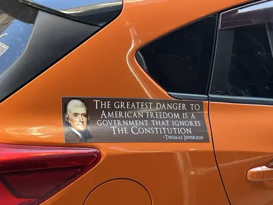 Sign seen on an orange car:
A likeness of Thomas Jefferson with his words to the right, on a banner:

"THE GREATEST DANGER TO AMERICAN FREEDOM IS A GOVERNMENT THAT IGNORES THE CONSTITUTION" 
- THOMAS JEFFERSON
 
