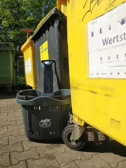 Einkaufskorb neben Wertstofftonne