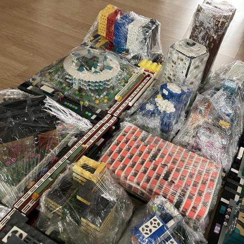 Several micropolis blocks each wrapped in clingfilm, laid out on a wooden floor. 