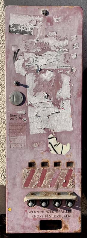 Ein alter Verkaufsautomat an einer Hauswand. Rot, verblichen und man erkennt nicht, was mal darin verkauft wurde.