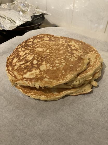 A stack of pancakes resting on a baking tray