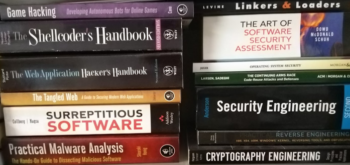 A collection of relatively neatly-stacked books about security: Game Hacking, Shellcoder's Handbook, WebApplication Hacker's Handbook, The Tangled Web, Surreptitious Software, Practical Malware Analysis, Linkers & Loaders Operating Systems Security, Code-Reuse Attacks and Defenses, Security Engineering, Reverse Engineering, Cryptography Engineering