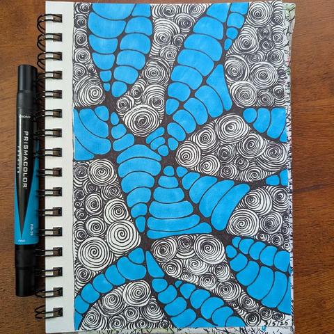 image of hand drawn spirals in black ink interspersed with blue organic worm like shapes