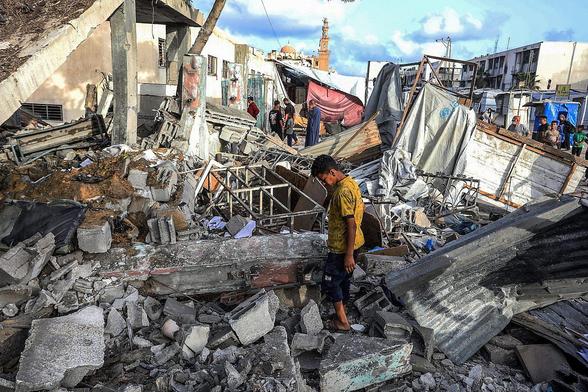 Palestiniens sur le site d'une frappe aérienne israélienne à Khan Younis, dans le sud de la bande de Gaza, le 19 mai 2025. 
