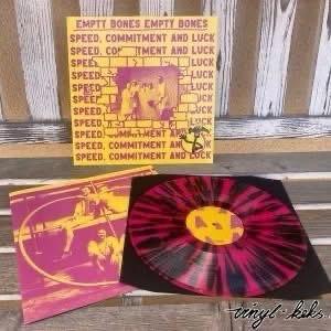 Eine künstlerische Darstellung einer Schallplatte und ihres Covers. Auf dem Cover ist ein fetter gelber Text auf einem strukturierten Hintergrund zu lesen: "EMPTY BONES EMPTY BONES" neben "SPEED, COMMITMENT AND LUCK". Das Vinyl selbst ist schwarz mit leuchtenden roten Streifen.