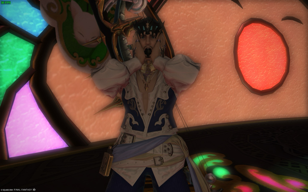 A surprised character from a video game stands in front of a large cartoon face inside a stained glass window. The character has light skin, blue eyes, and dark hair, and a spiky crown. They are wearing an elaborate outfit with a white ruffled shirt, a blue and white vest, and a wide belt. Their hands are raised to their face in a gesture of shock. The stained glass window features geometric shapes in green, pink, and other colors.