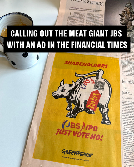 A cup of coffee sits beside a page of the Financial Times newspaper showing a Greenpeace advertisement. The ad calls out Brazil-based meat giant JBS, warning that the company, which is behind one of the world’s most destructive supply chains linked to deforestation, climate chaos, and human rights abuses, plans to list on the New York Stock Exchange.