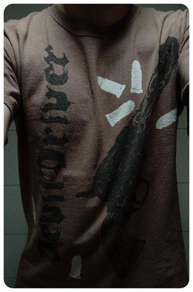T-shirt marron du groupe DevilDriver pour la chanson "Forgiveness is a Sixgun". 
Sur le devant on trouve un gros pistolet de cowboy avec six balles (forcément). 
Le nom de la chanson est écrite dans le dos.