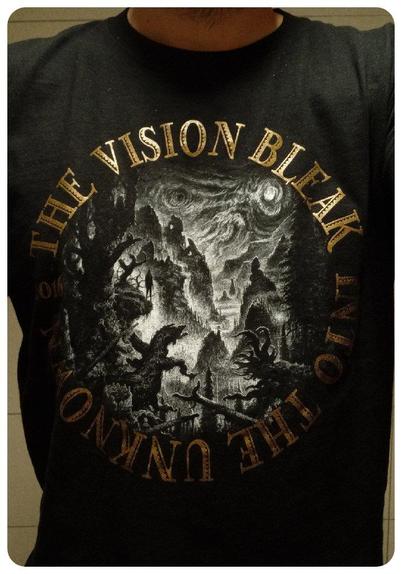 T-shirt manches longues du groupe The Vision Bleak pour la tournée "Into the Unknown" acheté au Ninkasi Kao le 03/11/2016. 
Design reprenant la pochette devant avec le nom du groupe et le titre de l'album en rond autour ainsi que l'année. 
La pochette est assez classique pour un groupe gothique avec une vision macabre d'un décors de montagne comprenant une silhouette que l'on peut distinguer en hauteur. 
Dans le dos, c'est une "magnifique" photo du groupe qui fait la tête avec le nom de la tournée en-dessous. 
Les écritures sont en dorées/cuivrées et long des manches, on retrouve plusieurs fois le logo avec le loup.