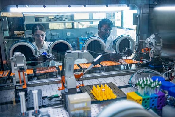 Forschende bereiten in den Handschuhboxen einer Robotikstrecke Komponenten für den Zusammenbau von Batterien vor