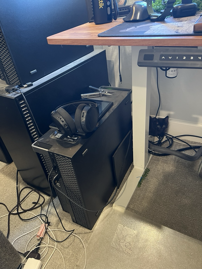 Tiny black cat curled up behind my workstations