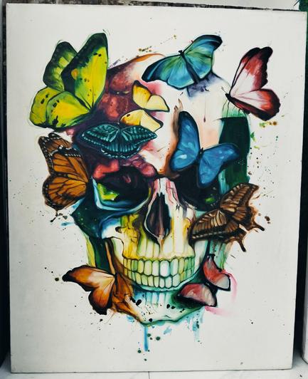 a painting of a skull with different colors on it, butterflies of all different colors landed on it 