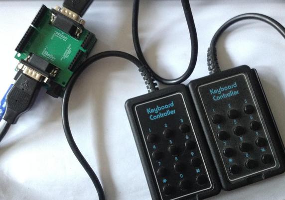 Photo of two Atari 2600 keyboard controllers plugged into a custom PCB on an Arduino Uno.
