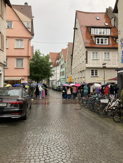 Viele Leute warten draußen im Regen auf den Anfang der Signierstunde. 