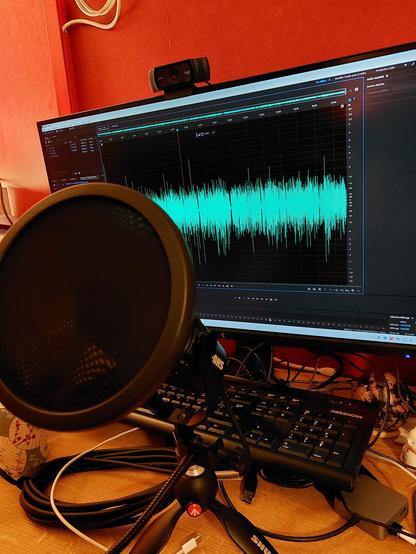 Photo d'un micro et d'un autant d'ordinateur sur l'écran duquel on voit un logiciel de traitement de son.