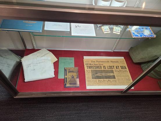 A display of maritime items at the new Albacore Park exhibit including an old newspaper, books, and clothing, matchboxes, and more!