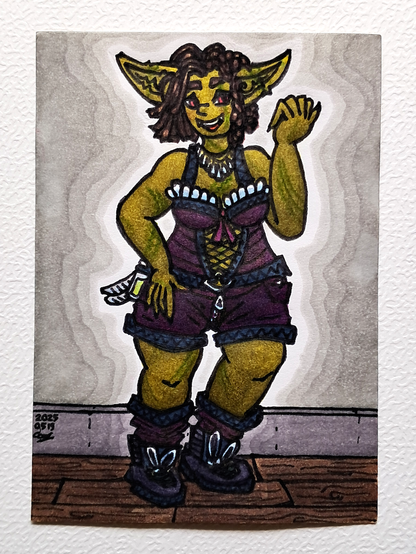 Un dessin faisant le portrait d'une gobeline à la peau verte et abîmée, portant un corset violet bordé de noire et avec des froufrous blancs au dessus du soutien-gorge, ainsi qu'un short et des bottes aux mêmes couleurs ; elle porte également une fiole et deux lames ; ses yeux sont rouges, ses cheveux bruns droits d'un côté et noués de l'autre et elle sourit d'un large sourire montrant 2 canines ; elle se tient debout, une main sur la cuisse droite et l'autre fermée devant sa tête, sur un parquet et devant un mur gris avec une plinthe d'un autre gris.