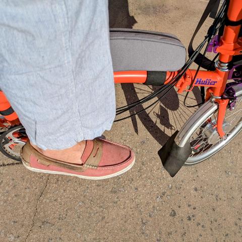 A photo of my right foot on the pedal of a 

orange Brompton folding bike with its name, Huffer, in purple on the top tube

I'm wearing

Mauve canvas penny loafers with no socks under a pinstriped pantleg