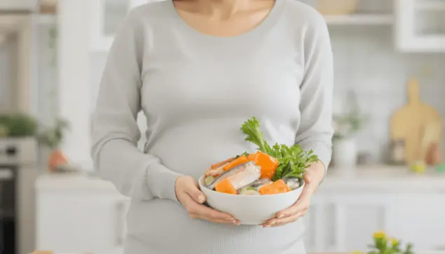 Pregnant woman smiling gently, holding a bowl of colorful fish and vegetables in a bright, clean kitchen, symbolizing healthy pregnancy nutrition.