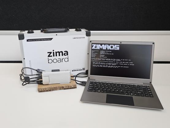 ZimaBoard 2 single-board computer connected to CrowView Note laptop-style keyboard+display, with a fancy branded briefcase behind it