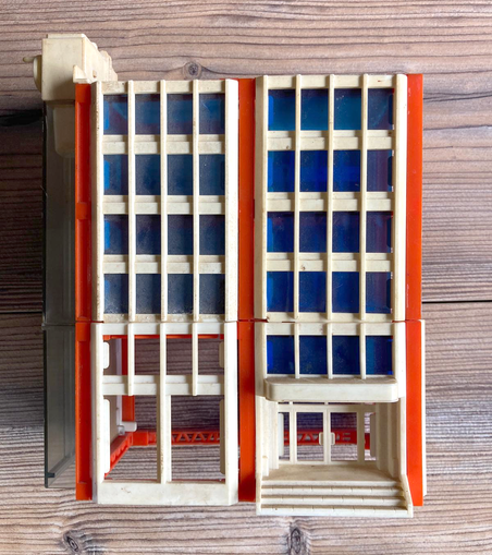 a tiny construction modular flat with orange beams, white windowsills and blue tinted windows.