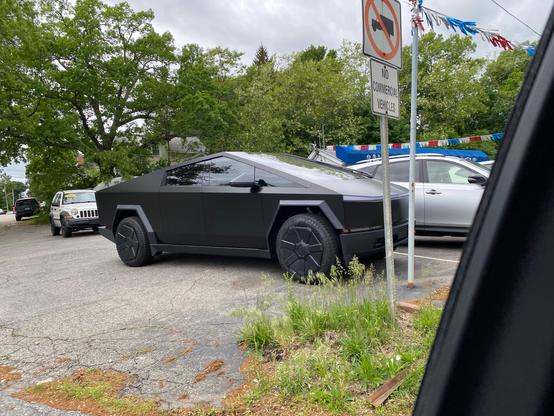 Picture of a Cybertruck with a kinda sad black wrap sitting at the far end of a line of cars on a slightly overgrown car lot.
It’s unclear whether it’s actual for sale or if it’s there to attract attention. (It’s actually pretty hard to see if you’re on the same side of the road as the car lot)