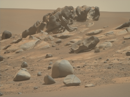 An ochre toned image capturing a rock outcrop on Mars. 