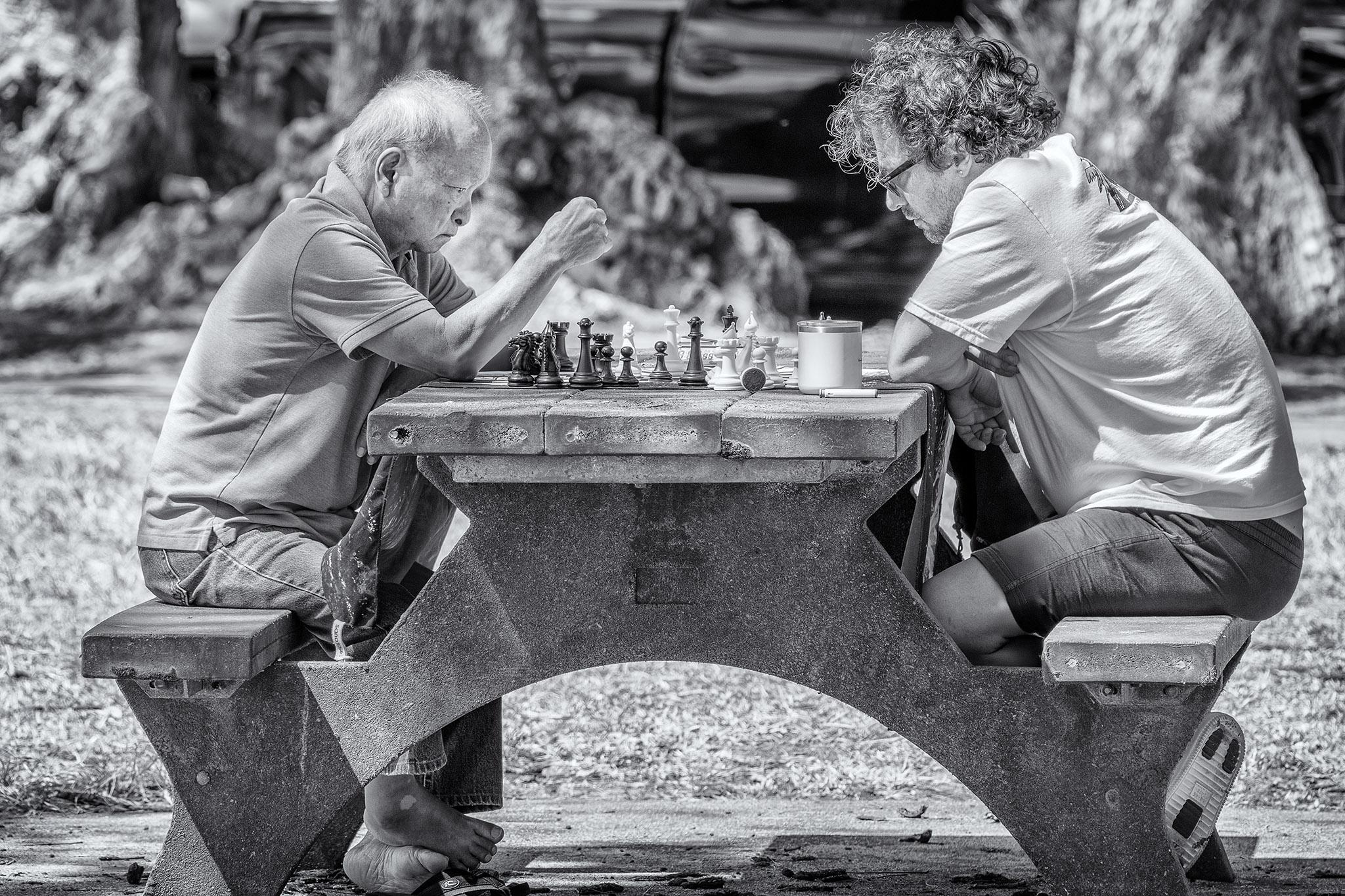 Two men play chess in a park near Waikiki Beach in Honolulu, Hawaii.