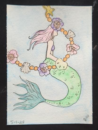 Mermaid surround by a flower garland made of pansies and seashells 