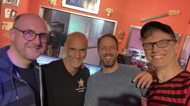 Gruppenfoto mit happy Band im Studio. Siehe Text. 