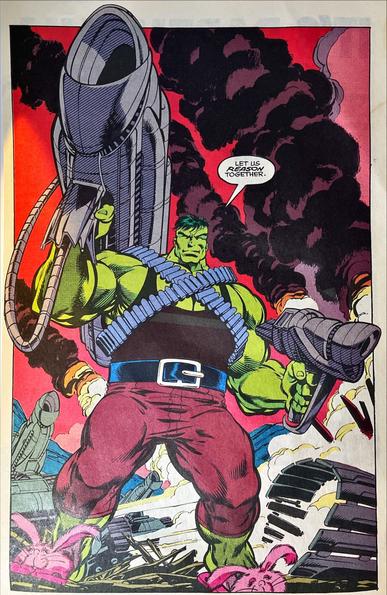 Incredible Hulk #390 interior splash page – Green Hulk stands amid wrecked armor and roiling black smoke, criss‑crossed bandoliers feeding two titanic chain guns that blaze shell casings across the scene; he calmly declares, “Let us reason together,” his menace amusingly undercut by a pair of oversized pink bunny slippers on his feet.