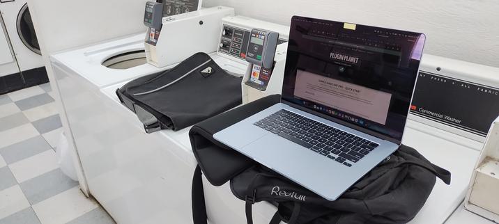 Photo of my laptop and bags sitting on a washer at a laundromat