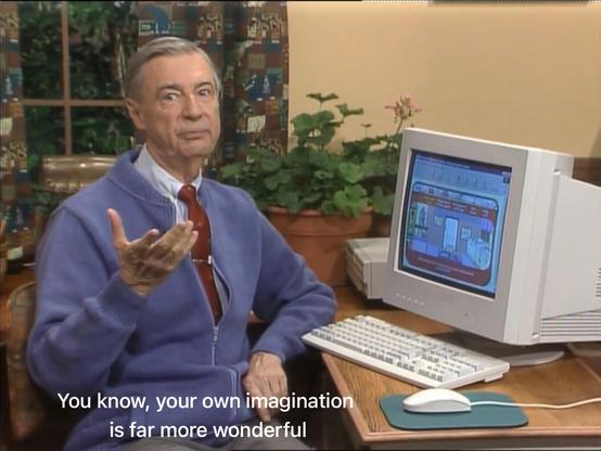 Screenshot of the Mister Roger's Neighborhood show. Mister Rogers sits in front of a mid-1990s-style PC, looking at the camera as he says, “You know, your own imagination is far more wonderful.”
