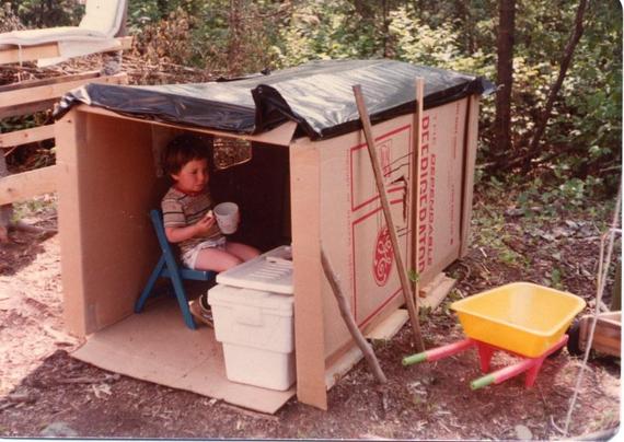 vintage photo of an old refrigerator box with a kid hanging out inside