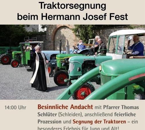 Eine Versammlung auf dem Hermann Josef Fest mit einer Segnung von Traktoren. Mehrere Oldtimer-Traktoren sind im Hintergrund geparkt, während ein Priester während einer Zeremonie gestikuliert. Die Teilnehmer, darunter einige ältere Männer, beobachten die Veranstaltung.