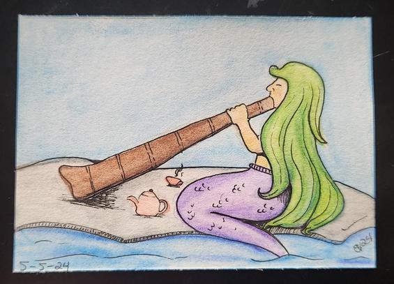 Mermaid on the beach playing the didgeridoo and drinking tea