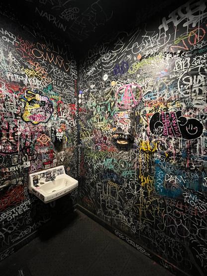 Heavy graffitied bathroom… sink is surprisingly clean.
