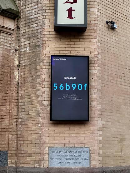 Close up of a video screen outside the church with a pairing code. 