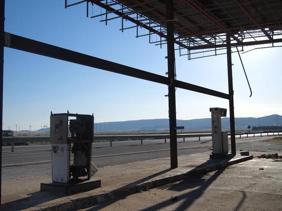 remnants of a petrol station, on the horizon wind turbines