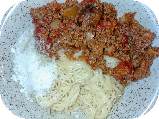 Assiette de spaghettis avec du ragoût de bœuf et du parmesan.