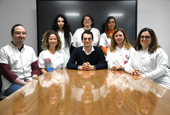 Photo de groupe prise dans un bureau hospitalier. L’équipe du centre de référence des pathologies plaquettaires de l’AP-HM est réunie autour du Dr Paul Saultier. On distingue sept personnes, en blouses blanches ou en tenue civile, souriantes, certaines assises et d’autres debout, devant une bibliothèque remplie de documents médicaux.