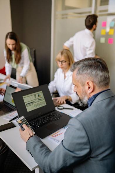 Business professionals collaborating on laptops in a modern office environment