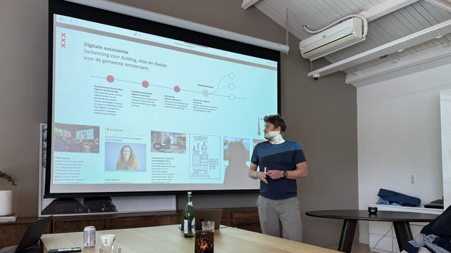 Aik van Eemeren voor de slide met daarop onderdelen die de aanleiding waren voor de digitale autonomie strategie bij gemeente Amsterdam 
